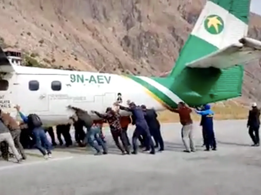 Au Népal, des passagers poussent un avion tombé en panne